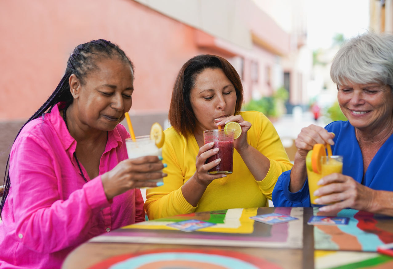 Three women enjoying drinks in an outdoor setting
