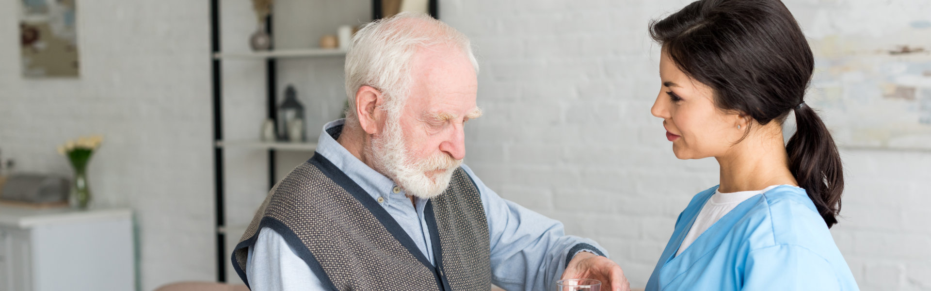 Caregiver assisting an elderly resident indoors.