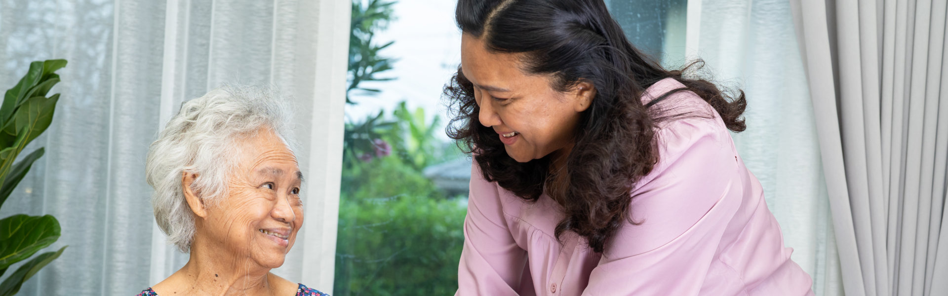 Caregiver interacting with a senior resident indoors.