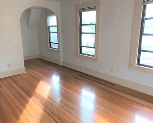 Bright interior room with hardwood floors and windows.