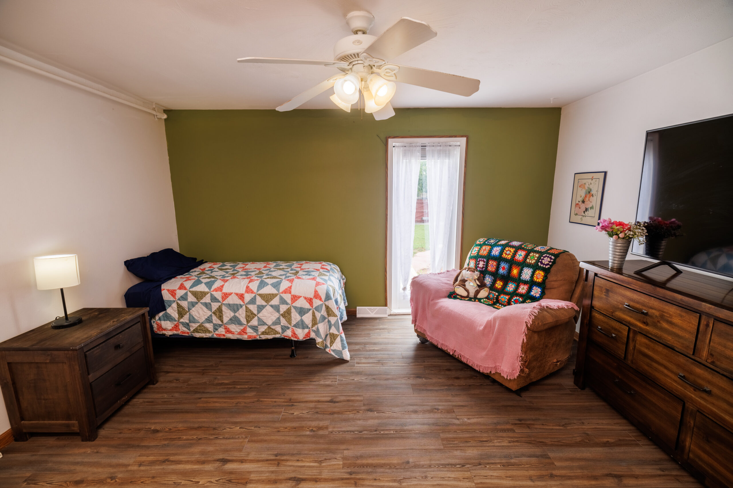 Cozy resident room with bedding and furniture.