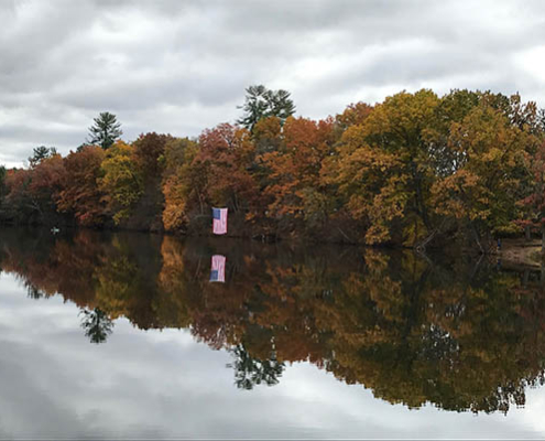 Autumn reflection on a lake with colorful trees.