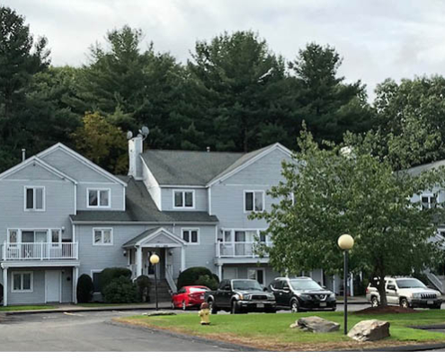 Exterior view of McKinley House with trees and parking.