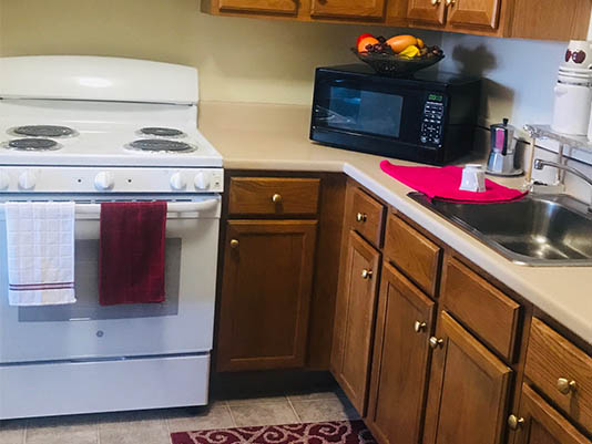 Kitchen area with appliances and fruit basket