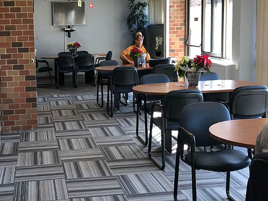Common area with tables and a resident.