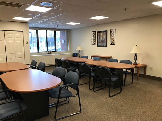 A spacious meeting room with tables and chairs.