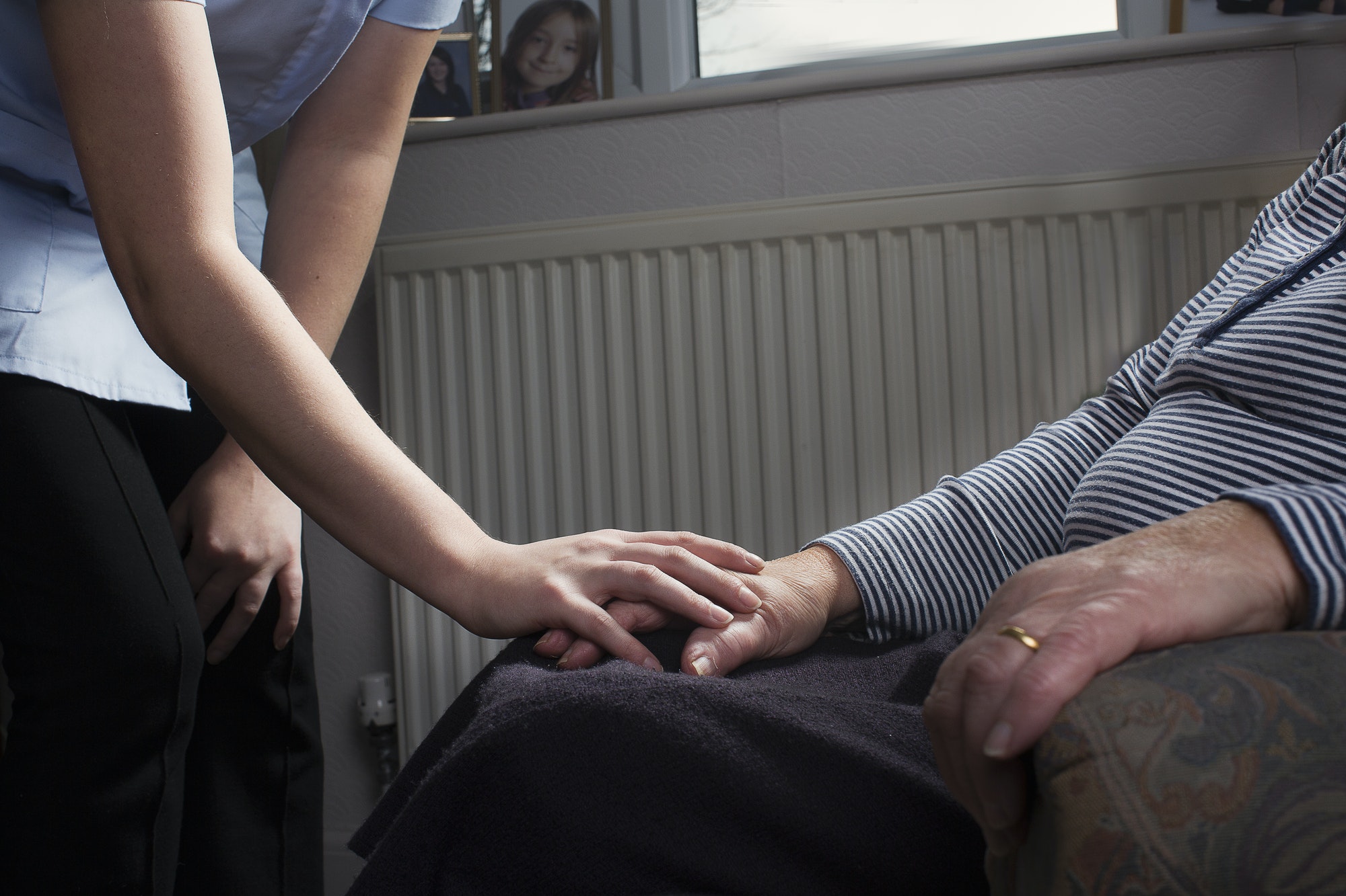 A caregiver holding hands with a resident.