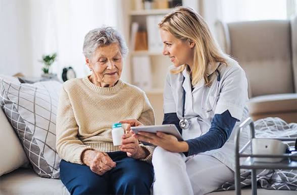 Nurse interacting with elderly resident in a cozy setting.