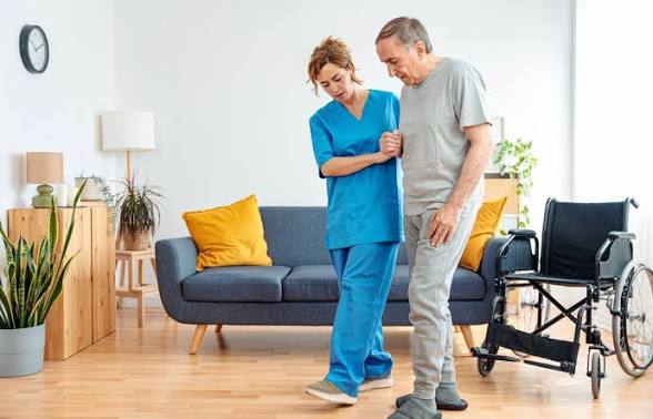 Staff assisting a resident in a living area