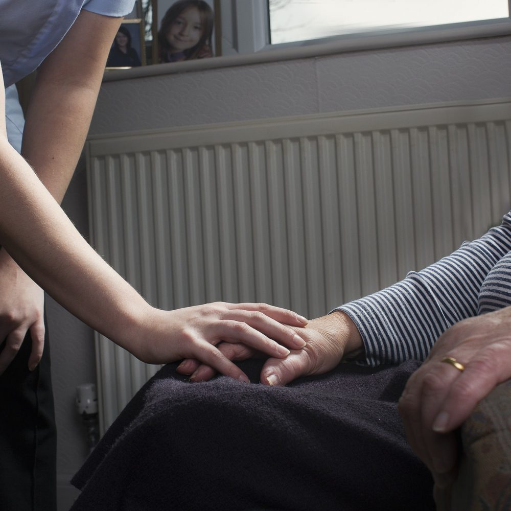 Caregiver holding hands with a resident.