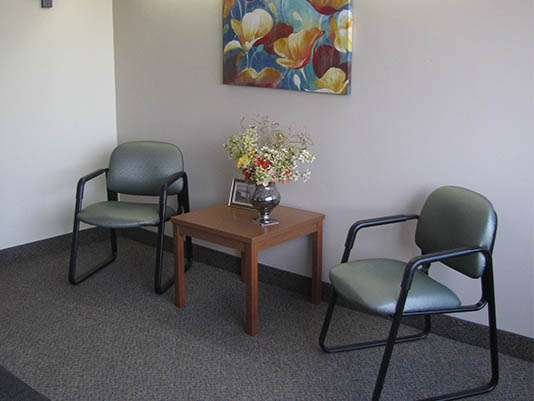 Seating area with floral artwork and table.