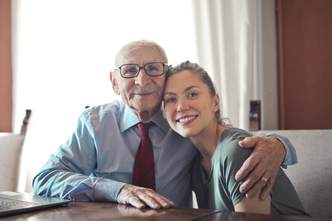 A senior man and a young woman smiling together