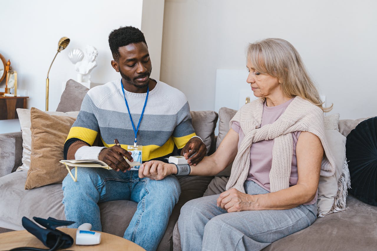 Healthcare worker assisting a senior woman at home.