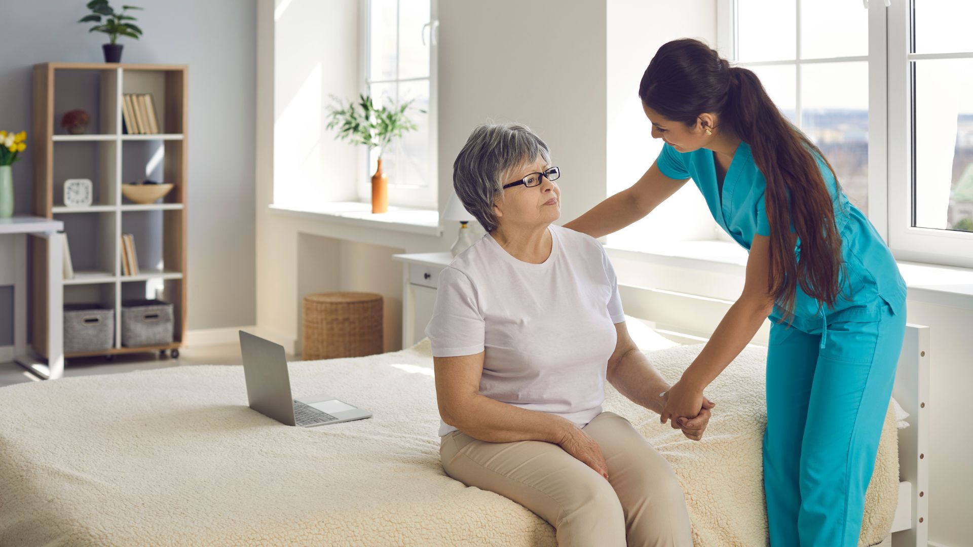 Nurse assisting a senior resident in a room.