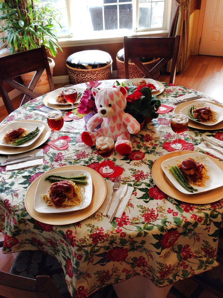 Dining table set with food and a teddy bear centerpiece.