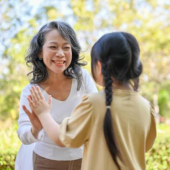 A woman greeting a child in an outdoor setting