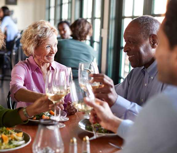 Residents enjoying a meal and toasting with glasses