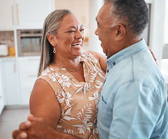 Two seniors dancing joyfully in a kitchen setting