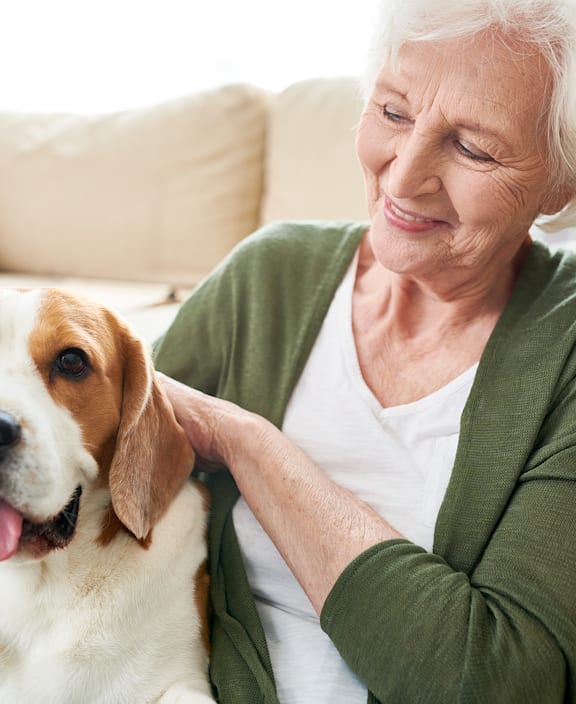 Senior woman sitting with a dog, smiling