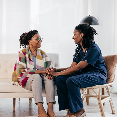 Caregiver holding hands with a resident indoors
