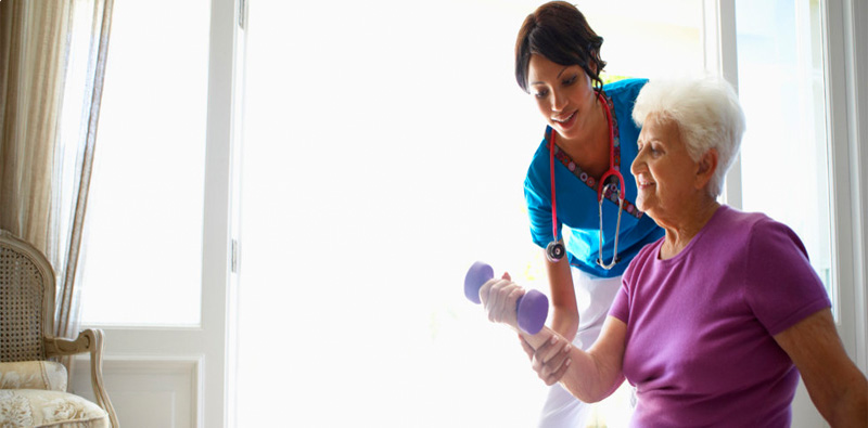 Staff assisting a resident with weights
