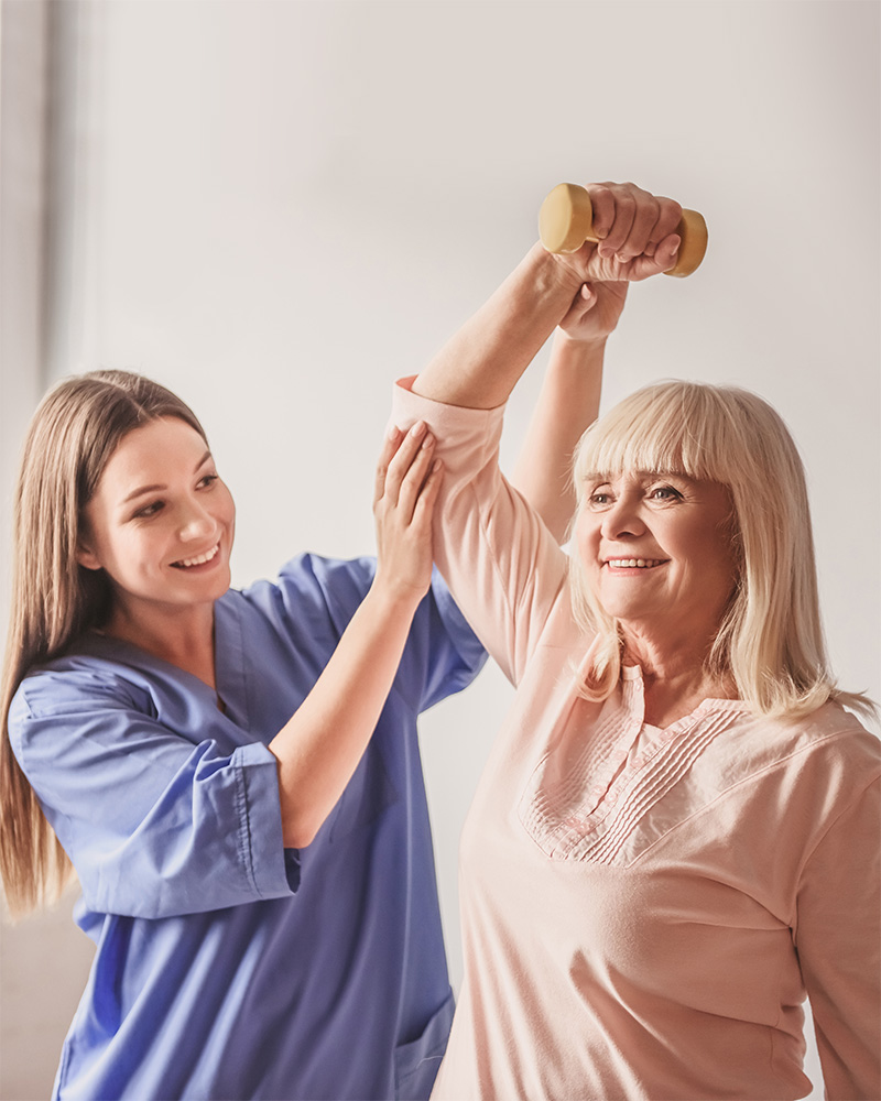 Senior resident receiving physical therapy with staff help