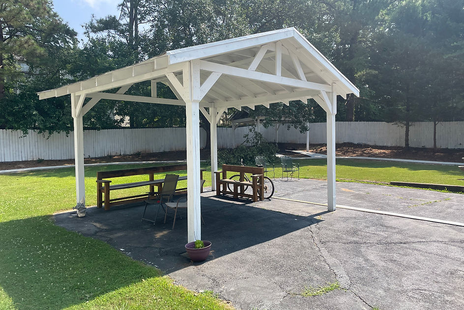 Outdoor shaded seating area with benches.
