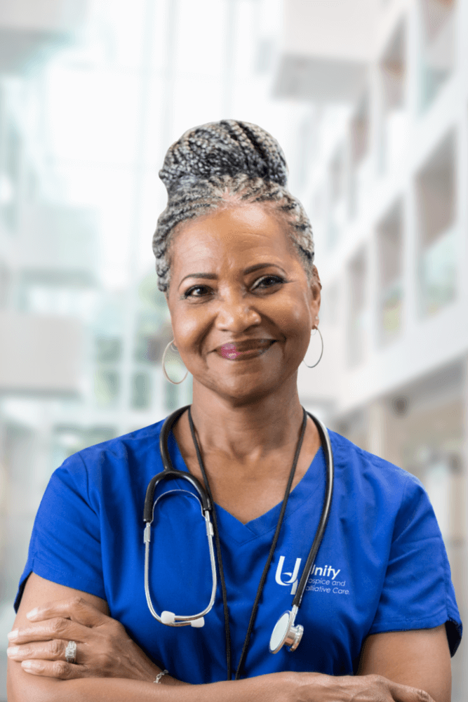 Nurse in a blue uniform smiling confidently.
