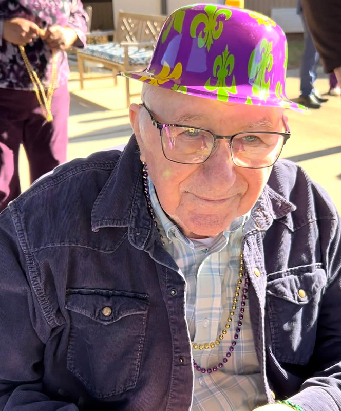 Elderly man wearing a festive hat.