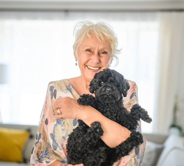 Senior woman smiling with a pet dog.
