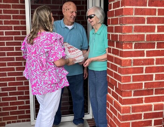 Two residents and a visitor at the entrance.