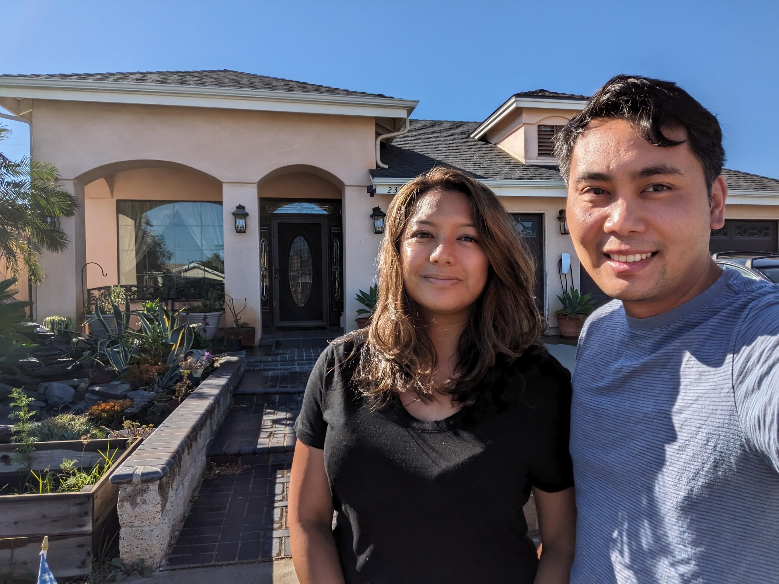 Two people standing in front of a residential building.