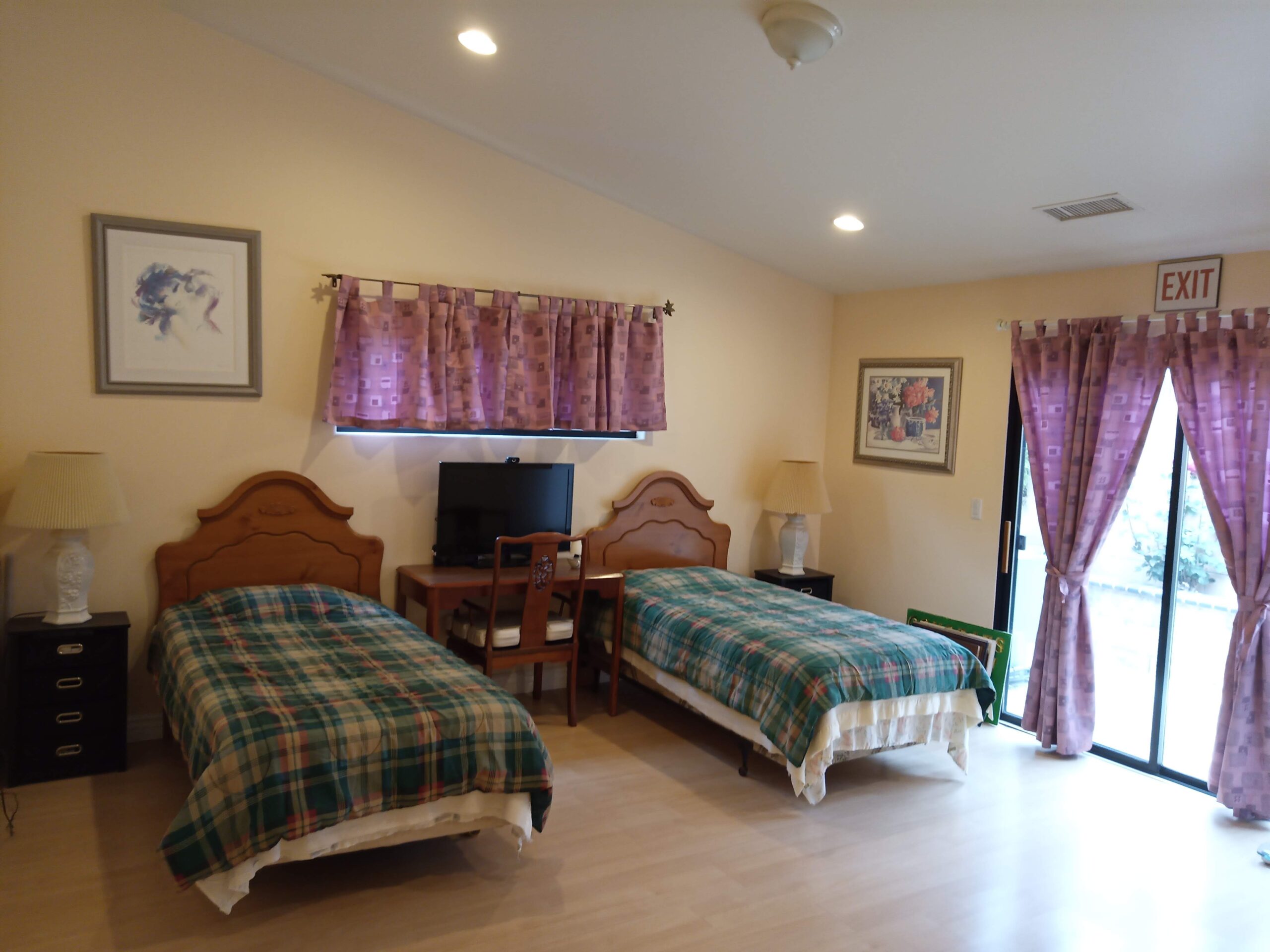 A cozy twin bedroom with two beds and a desk.