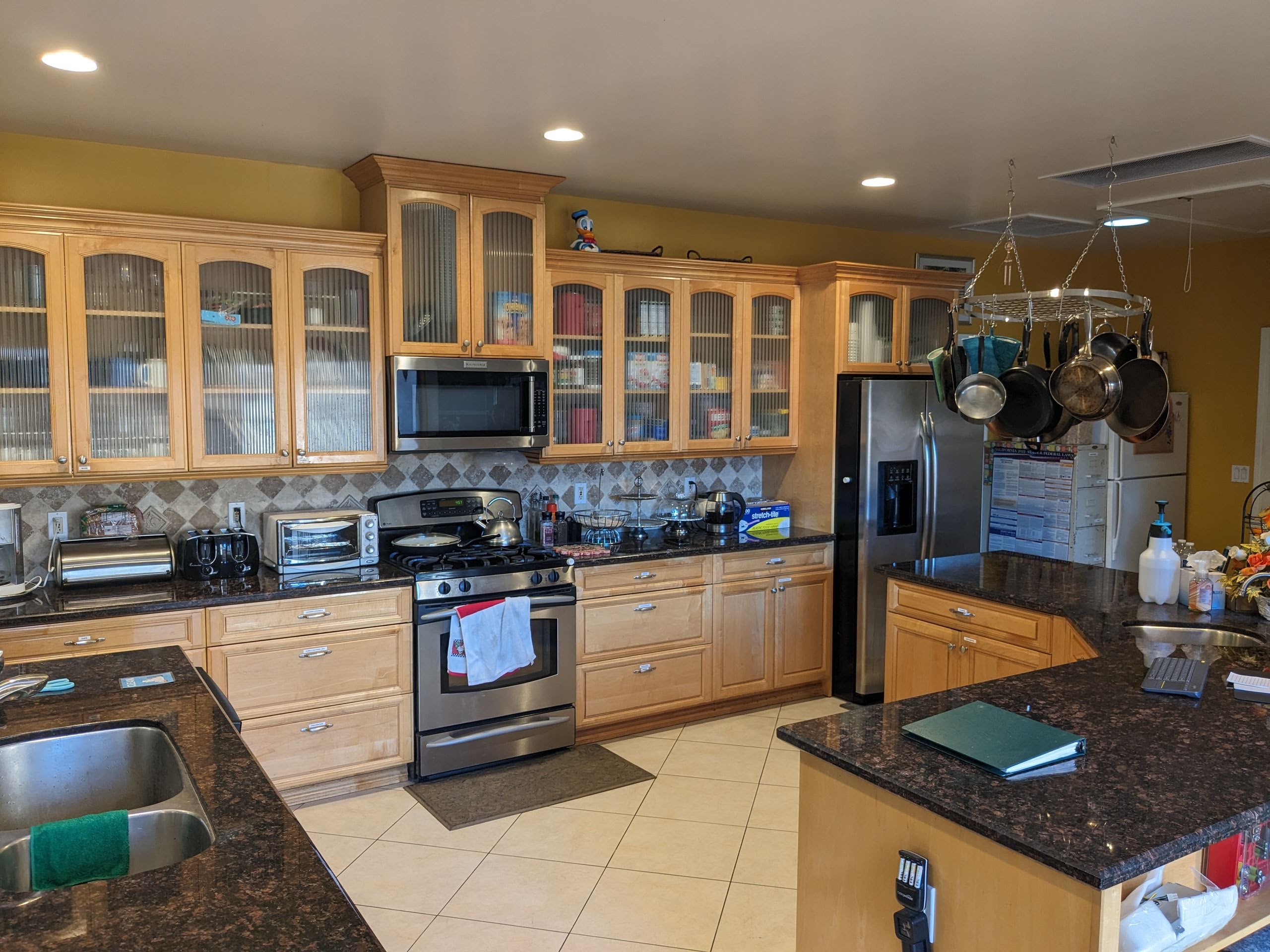 Spacious kitchen with wooden cabinets and stainless steel appliances.