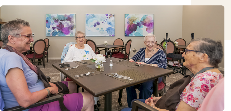 Seniors enjoying a meal together in the dining room.