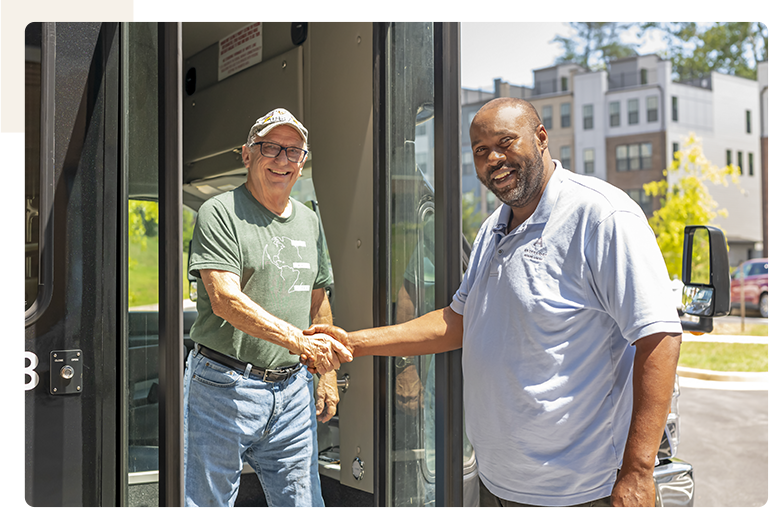 Residents and staff interacting outside a vehicle