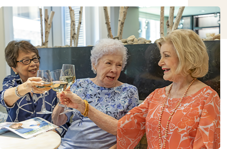 Three residents toasting with glasses at a gathering.