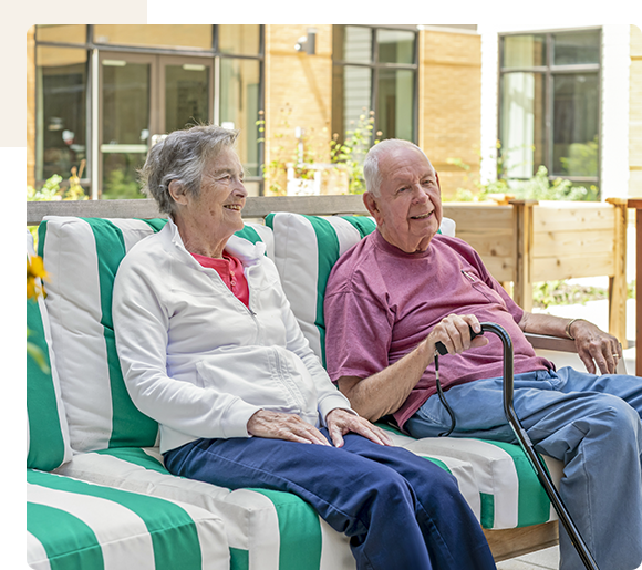 Two residents enjoying time outdoors on couches.