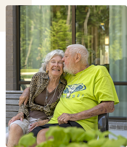 Elderly couple sharing a joyful moment outdoors.
