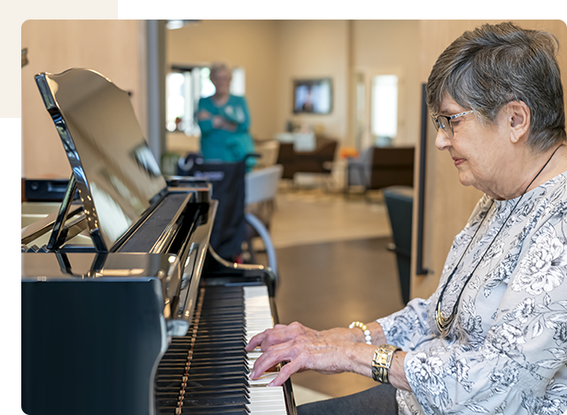 Resident playing piano in a common area.