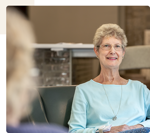 Senior woman smiling in a facility common area.