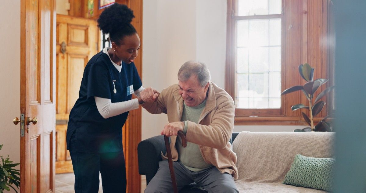 Caregiver assisting an aging man at home.