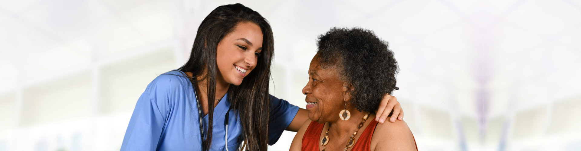 Nurse assisting an elderly woman with a warm smile