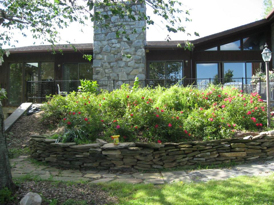 Outdoor garden area with stone wall and flowers.