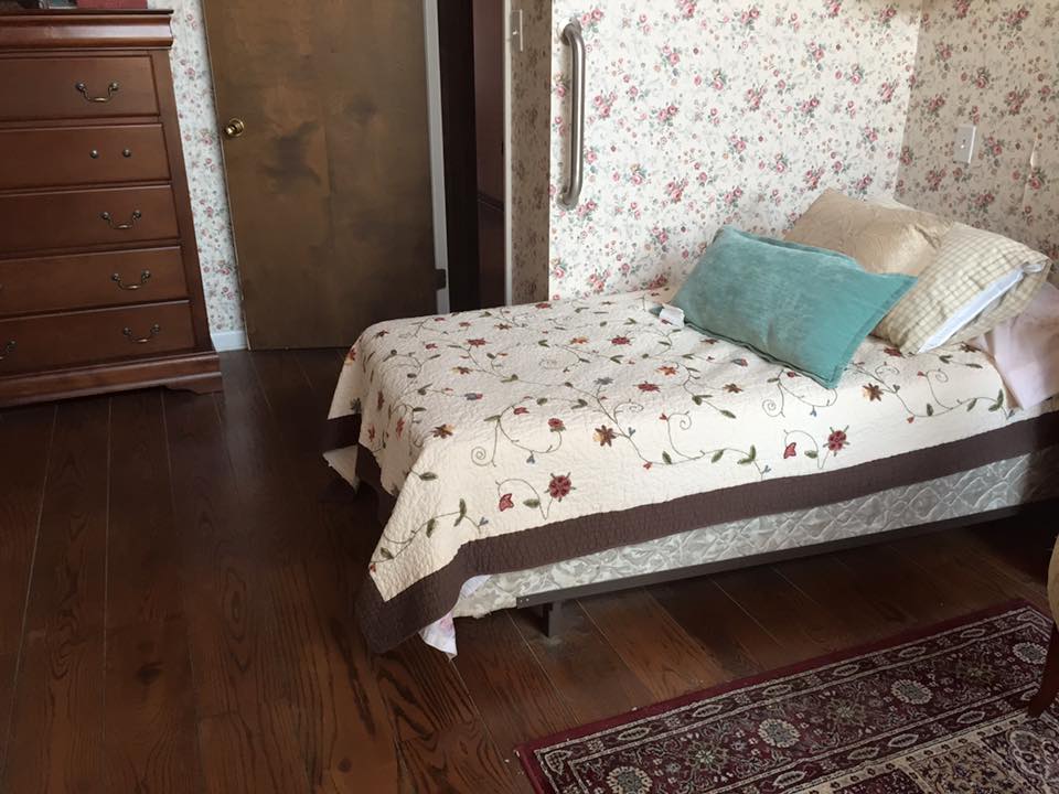 Cozy bedroom with floral wallpaper and wood furniture