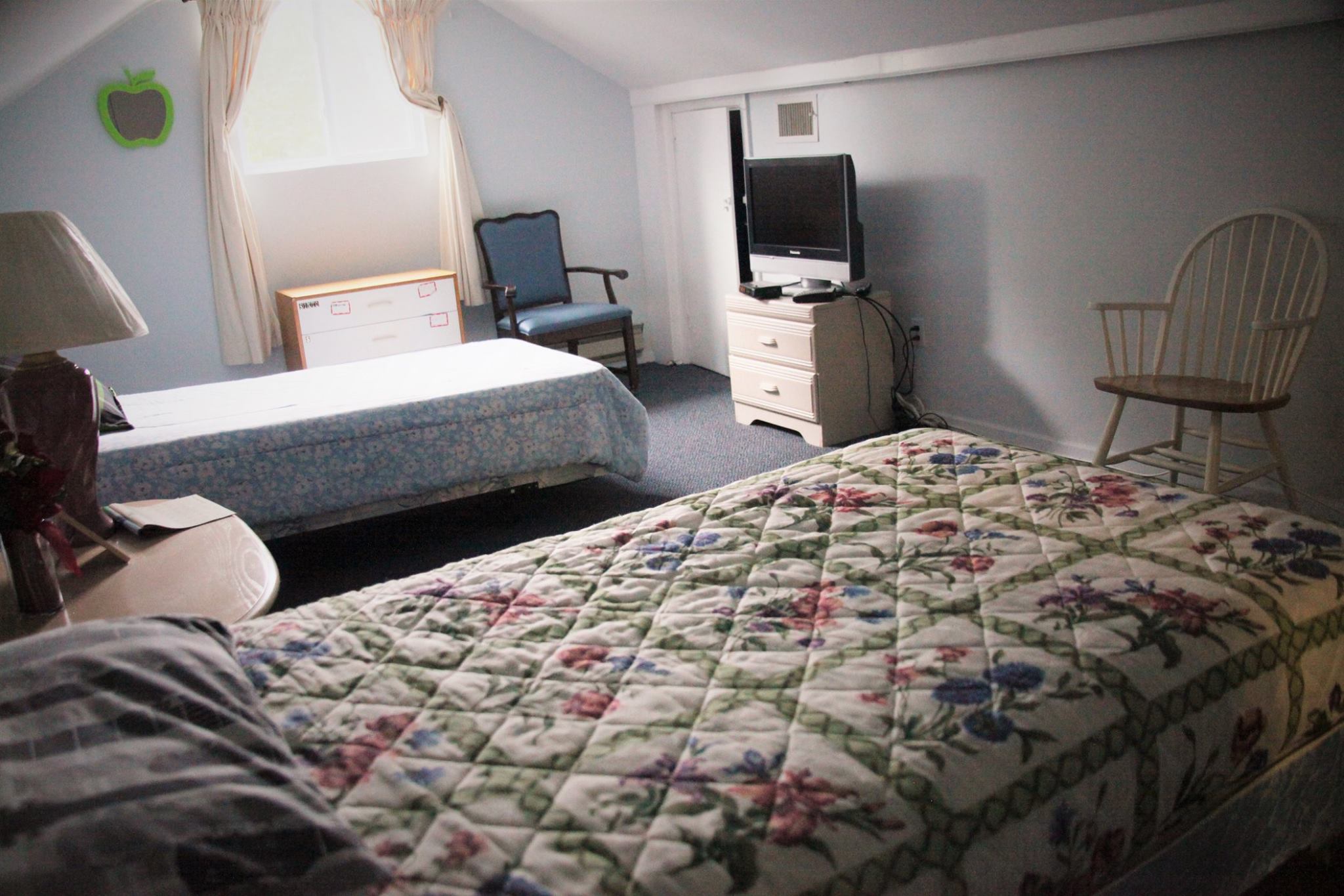 Cozy bedroom in a senior care facility with a floral quilt