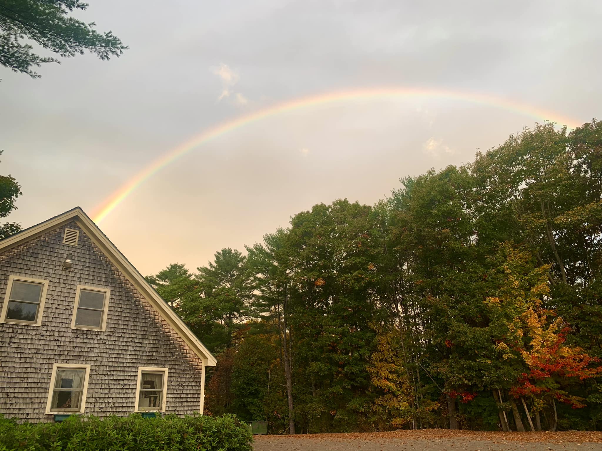 Building exterior under a rainbow with trees