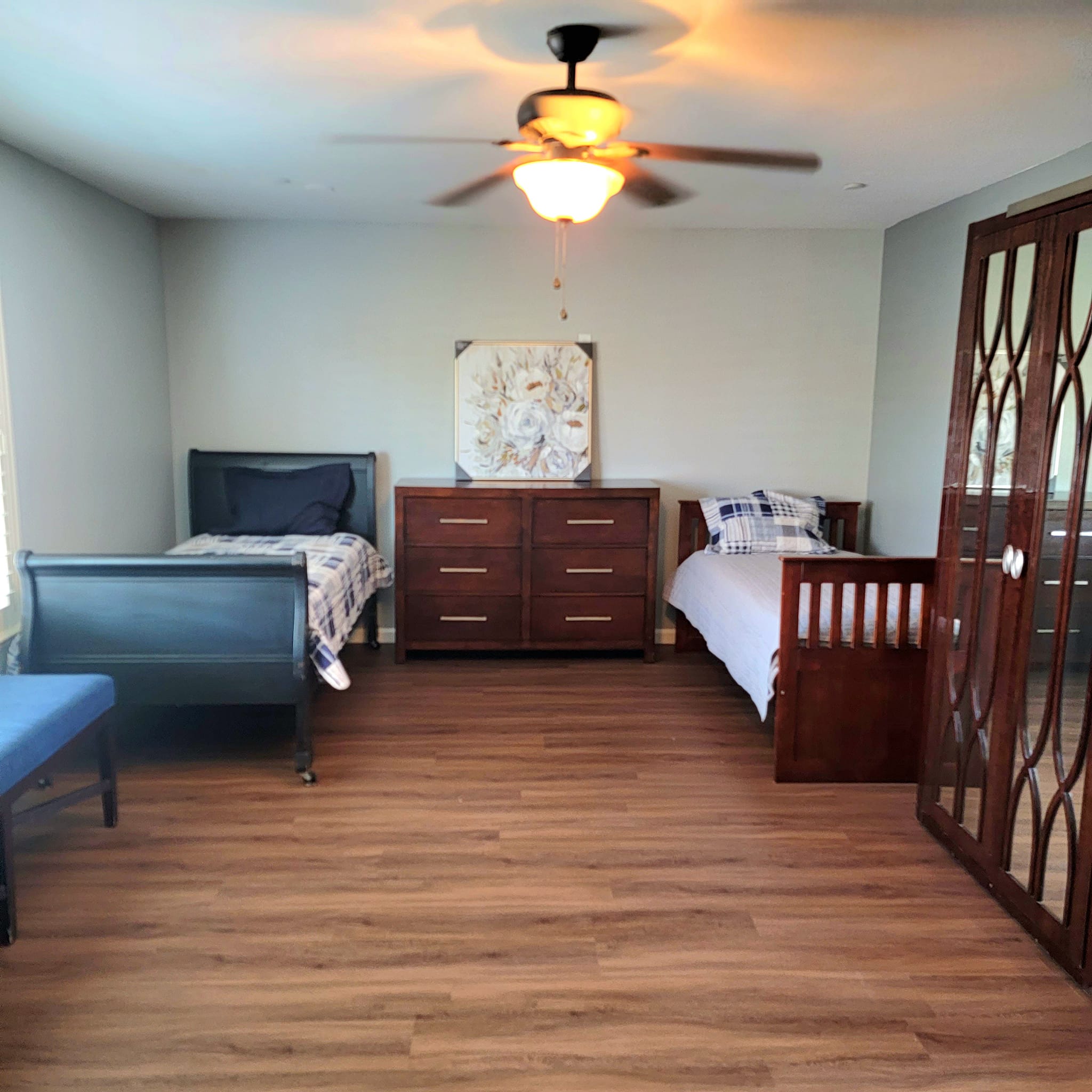 Private resident room with two beds and wooden furniture