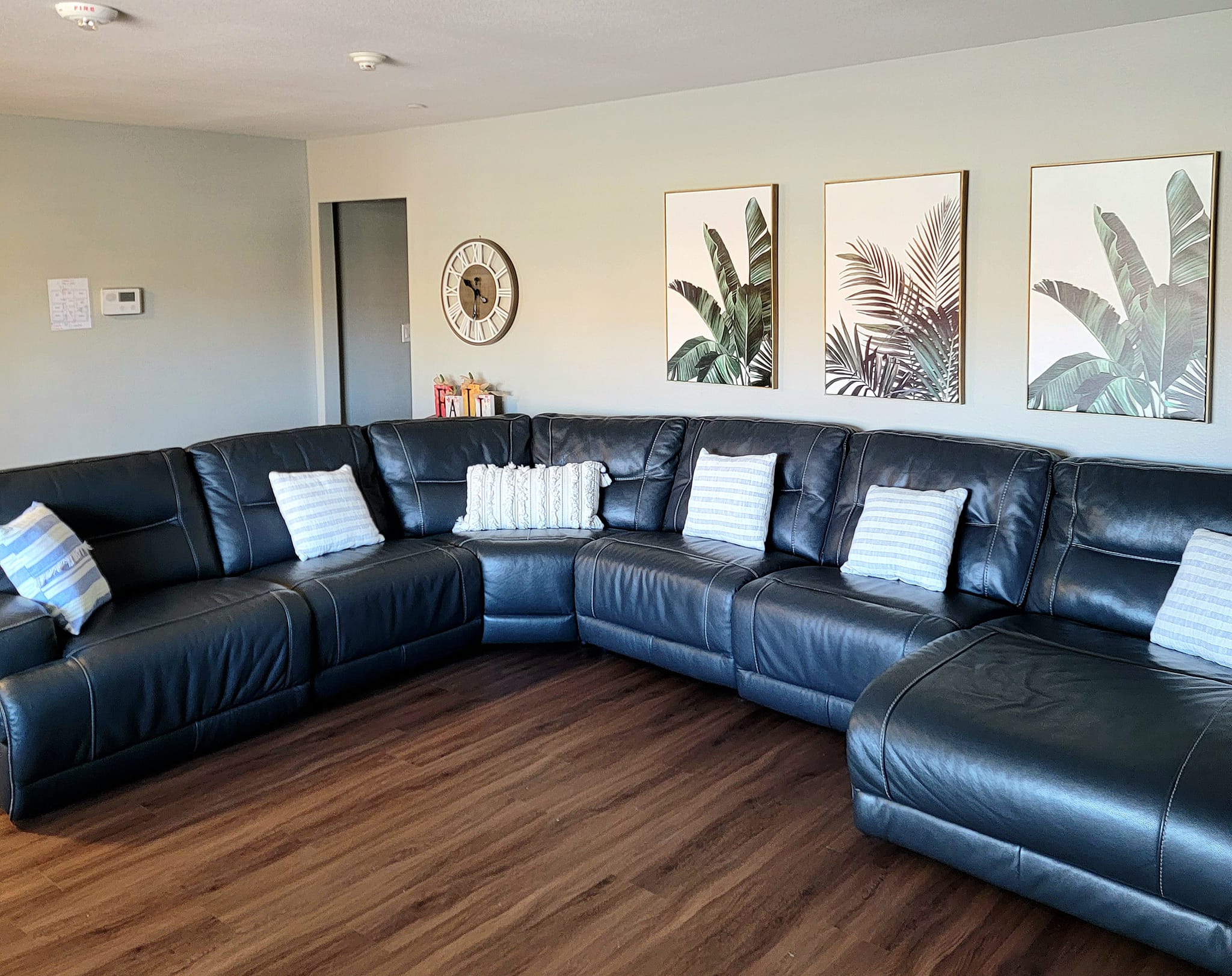 Cozy common area with a leather sectional sofa and wall art