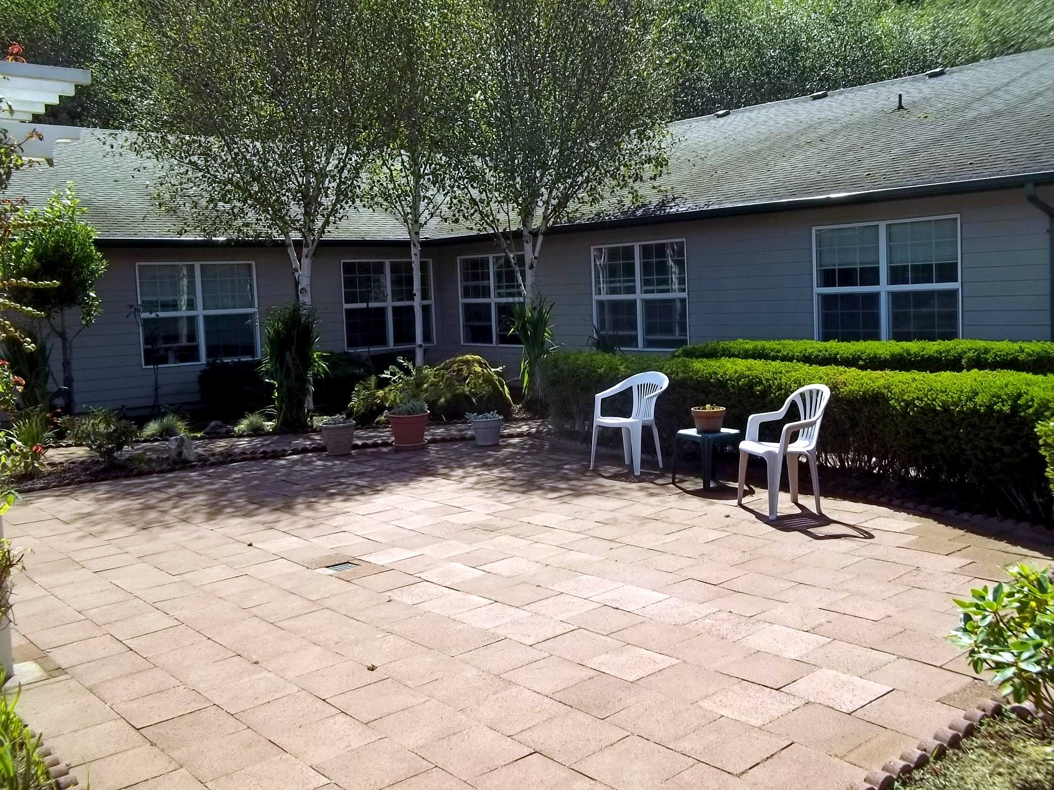 Outdoor patio area with chairs and landscaped surroundings